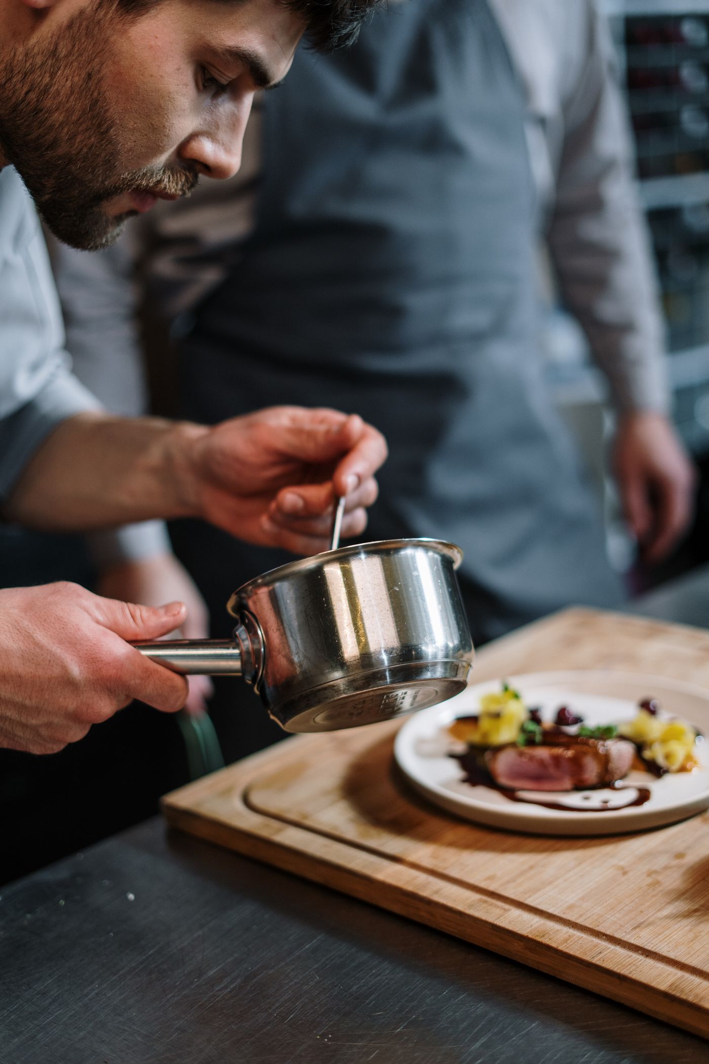 A cook finishing a plate